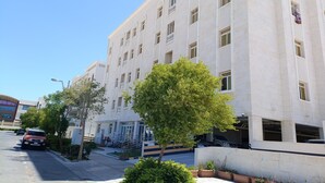 A multi-story building with a symmetrical facade, large windows, and a central entrance with steps.