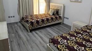 A bedroom with a bed, a nightstand, a window with curtains, and a painting on the wall.