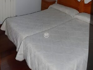Tabla de planchar con plancha y ropa de cama