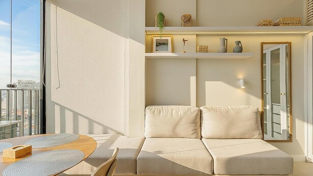 A modern living room with a sofa, a coffee table, and a balcony with a city view. - Aptos modernos em prédio com piscina a 300m do metrô - UOYs (São Paulo)