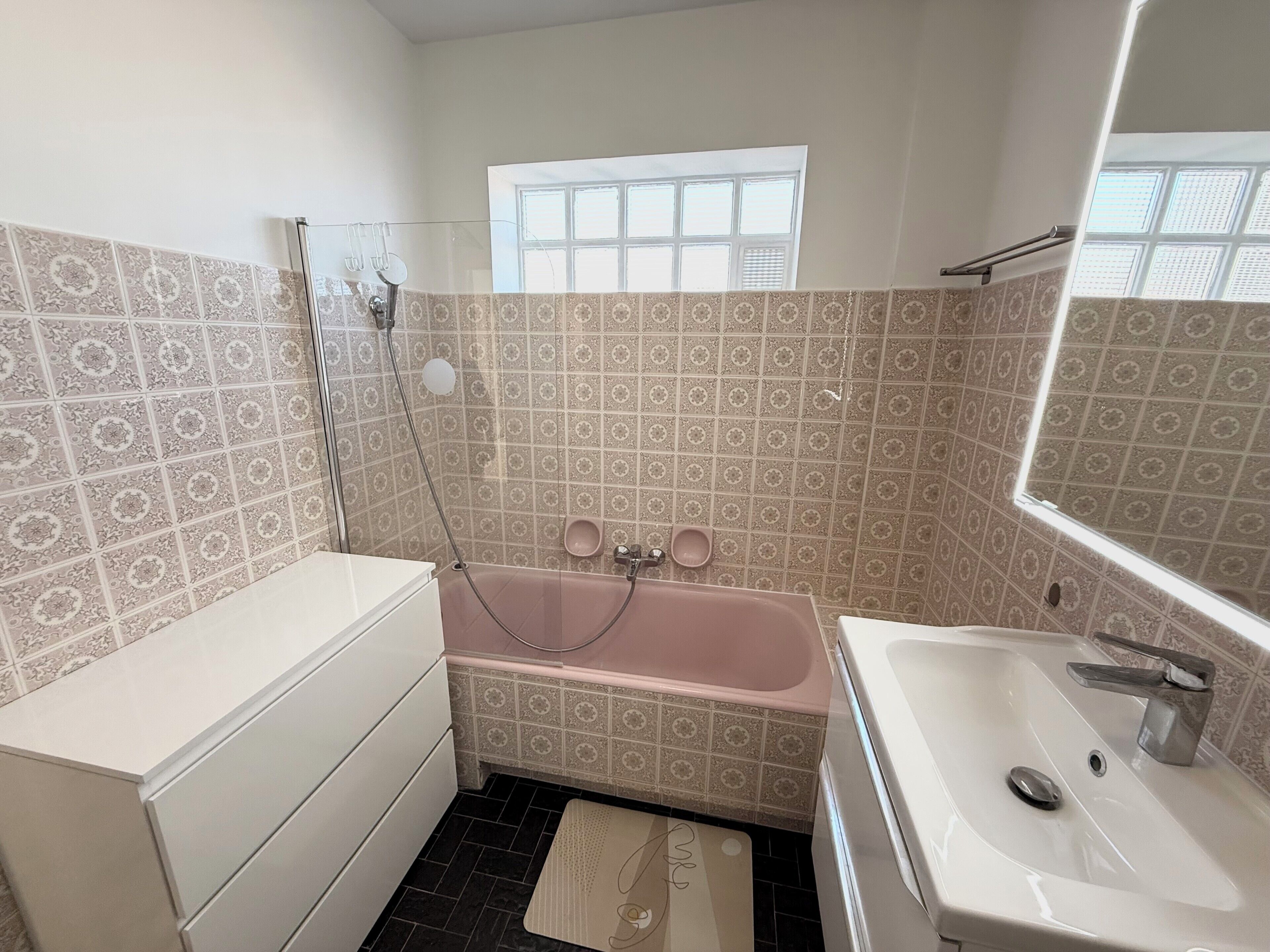 Un baño con bañera, lavamanos y ventana.