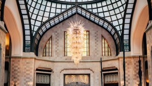 A grand hall with a high, arched glass ceiling and a central chandelier. - Four Seasons Hotel Gresham Palace Budapest (Budapest)