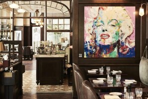 A restaurant interior with a large painting, dining tables, and a bar area. - Four Seasons Hotel Gresham Palace Budapest (Budapest)