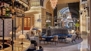 A spacious lobby with a curved bar, seating area, and a high ceiling with a glass dome. - Four Seasons Hotel Gresham Palace Budapest (Budapest)