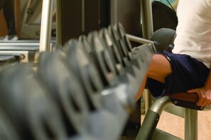 Una persona usando una máquina de prensa de piernas en un gimnasio.