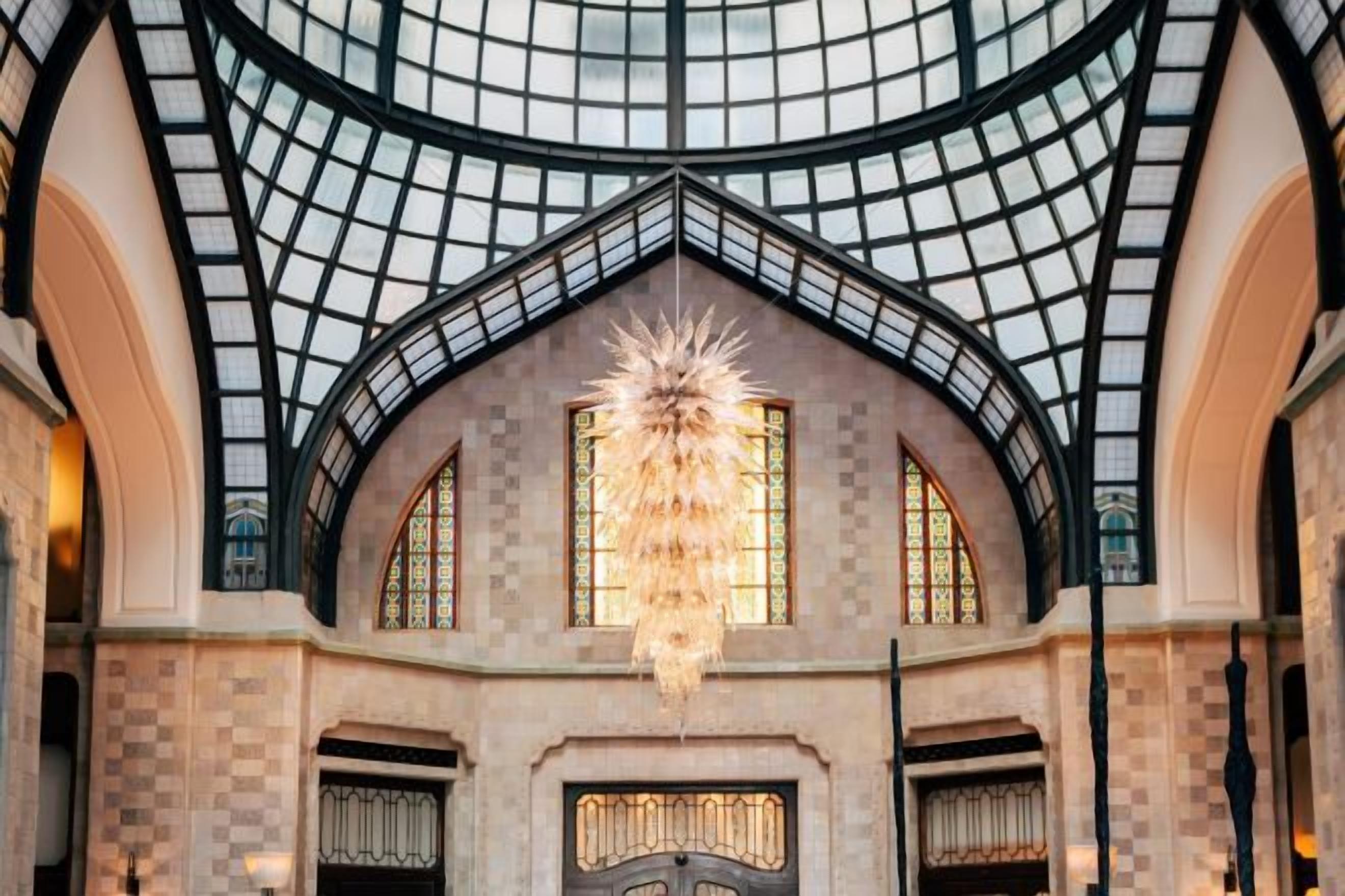 A grand hall with a high arched ceiling and a large chandelier.