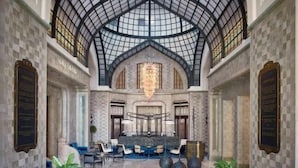 A spacious lobby with a high arched ceiling, a central seating area, and decorative plants. - Four Seasons Hotel Gresham Palace Budapest (Budapest)