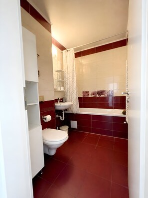 A bathroom with a toilet, sink, and bathtub. - Brasov Altipiani Apartments (Brașov)