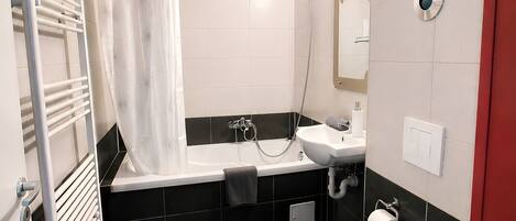 A modern bathroom with a bathtub, toilet, sink, and shower.