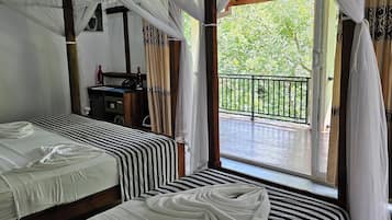 Deluxe Triple Room, Balcony, Garden View | Peti besi dalam bilik, meja, ruang kerja komputer riba, kalis bunyi