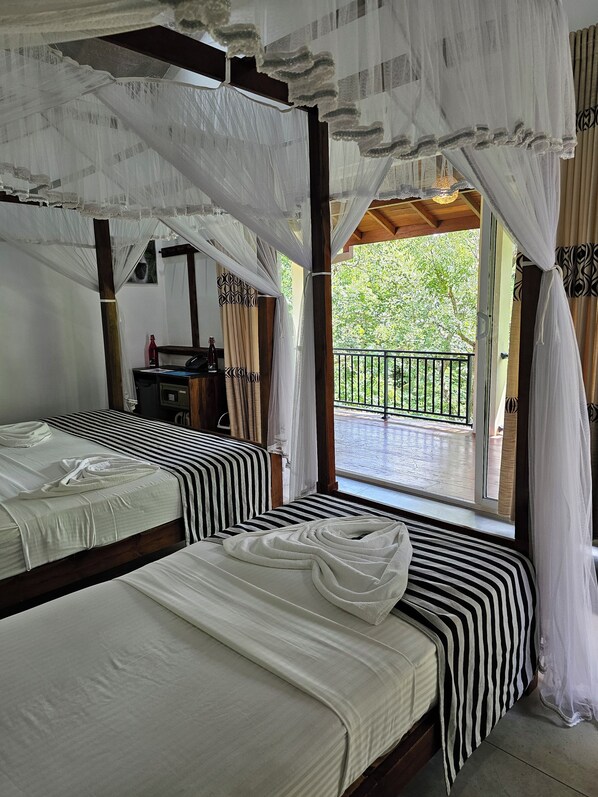 Deluxe Triple Room, Balcony, Garden View | Peti besi dalam bilik, meja, ruang kerja komputer riba, kalis bunyi 