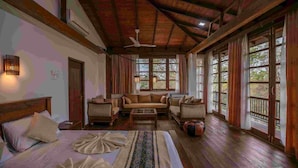 Une pièce spacieuse avec un grand lit, un canapé et un plafond en bois.