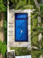 Una piscina al aire libre, sombrillas, tumbonas