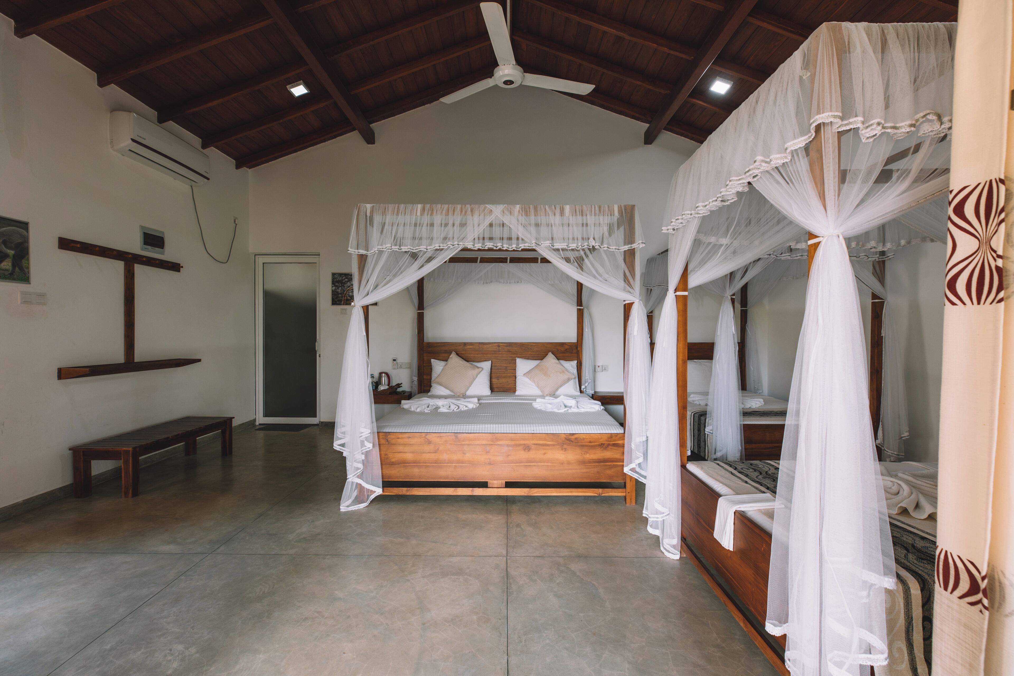 Ein geräumiges Schlafzimmer mit einem großen Bett, einem Holz-Kopfteil und einem Deckenventilator.