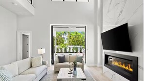 Un salon moderne avec un canapé, une table basse et une cheminée.