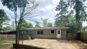 A single-story house with a covered patio area, a fenced yard, and a small attached garage. - Home Away From Home!!! (Birmingham)