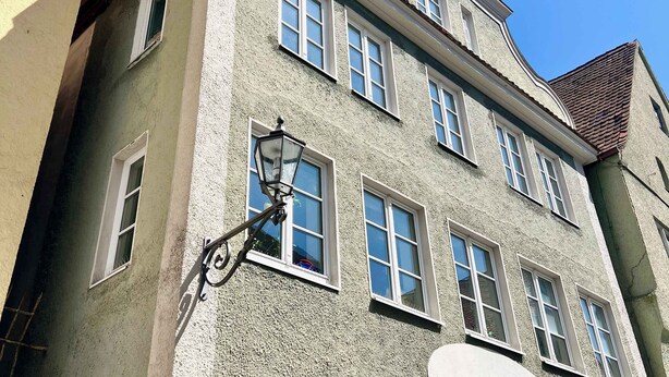 Un immeuble à plusieurs étages, doté d’une façade à motifs, de nombreuses fenêtres et d’un lampadaire traditionnel.