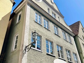 Un immeuble à plusieurs étages, doté d’une façade à motifs, de nombreuses fenêtres et d’un lampadaire traditionnel.
