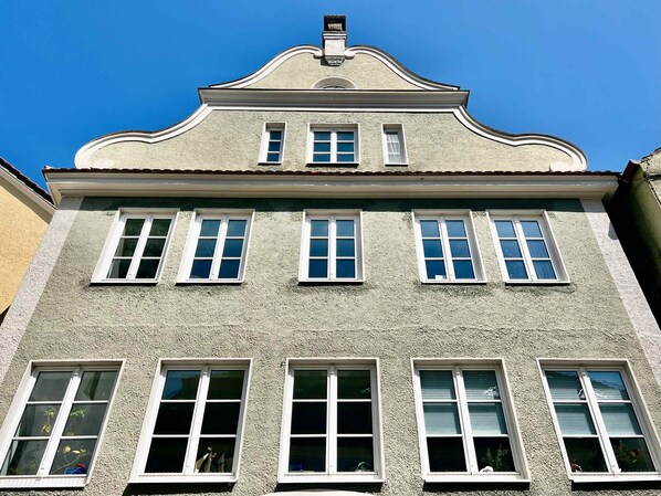 A building with a symmetrical facade, multiple windows, and a decorative cornice.