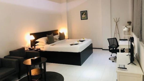 A modern hotel room with a bed, a desk, a chair, and a small round table. - Yama Hotel & Rooftop Bar (Botataung)