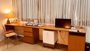 A hotel room with a wooden desk, a television, a mini-fridge, a lamp, and a chair. - Yama Hotel & Rooftop Bar (Botataung)