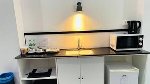 A compact kitchenette with a microwave, kettle, and a small refrigerator. - Yama Hotel & Rooftop Bar (Botataung)