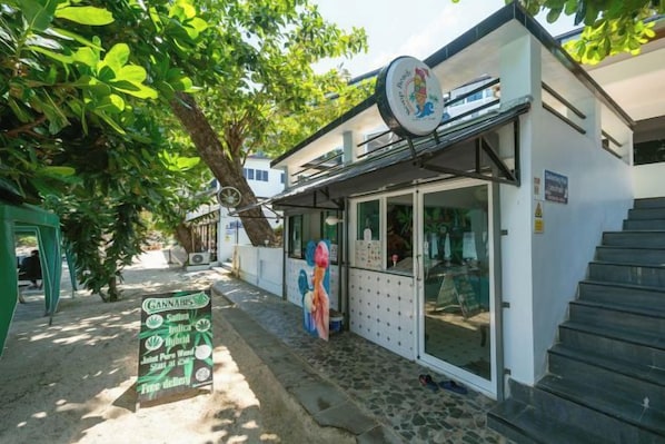 A storefront with a signboard listing cannabis products. - The Hideout Beachfront (Phuket)