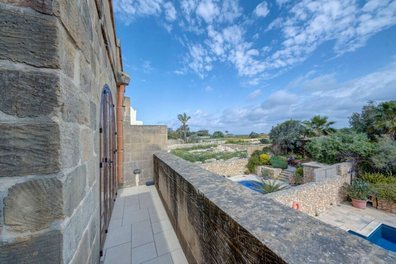 A stone building with a pool and garden.