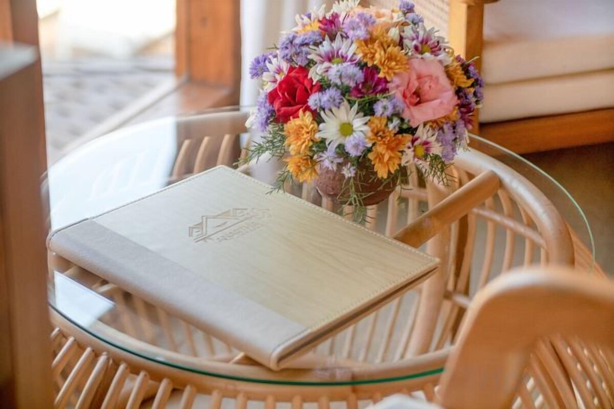 A glass table with a notebook and a bouquet of flowers.