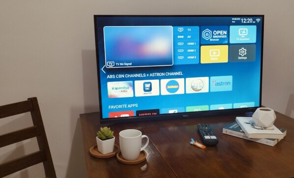 A television displaying a TV guide interface with channel listings and app icons. - NAIA MNL Airport-Newport Accommodations (Pasay)