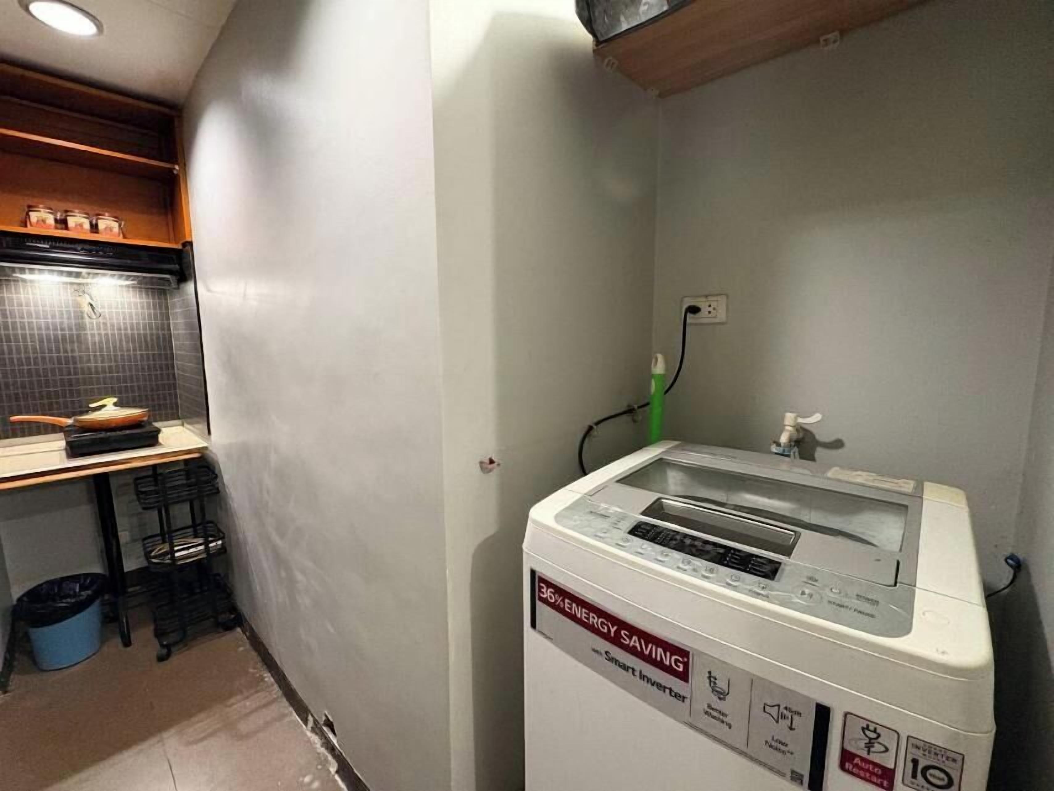 A compact kitchen with a microwave oven, a sink, and a countertop with a frying pan.
