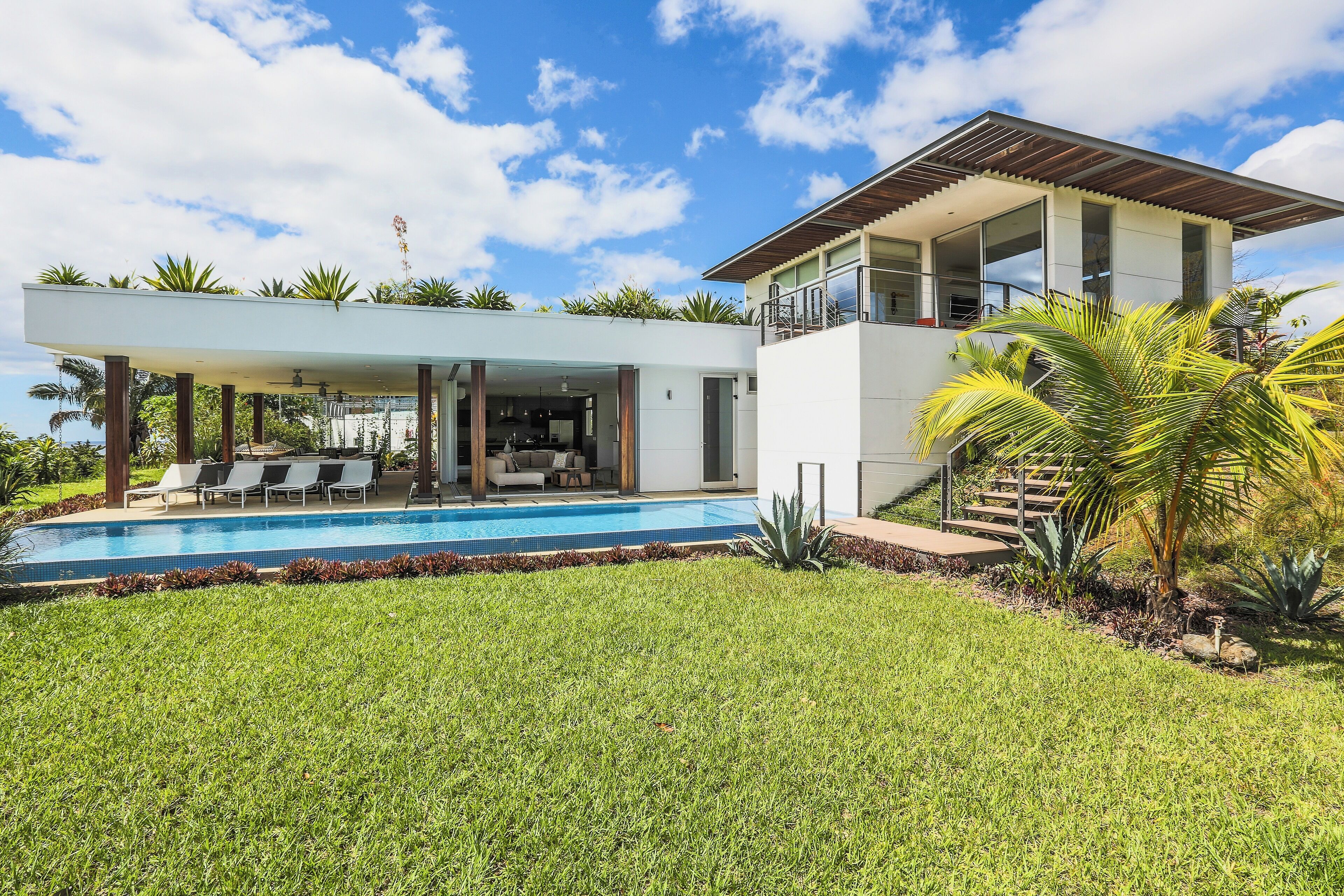 A modern house with a swimming pool, a covered patio, and a two-story structure.