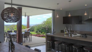 Una cocina moderna con una isla grande, taburetes de bar y vistas al exterior.