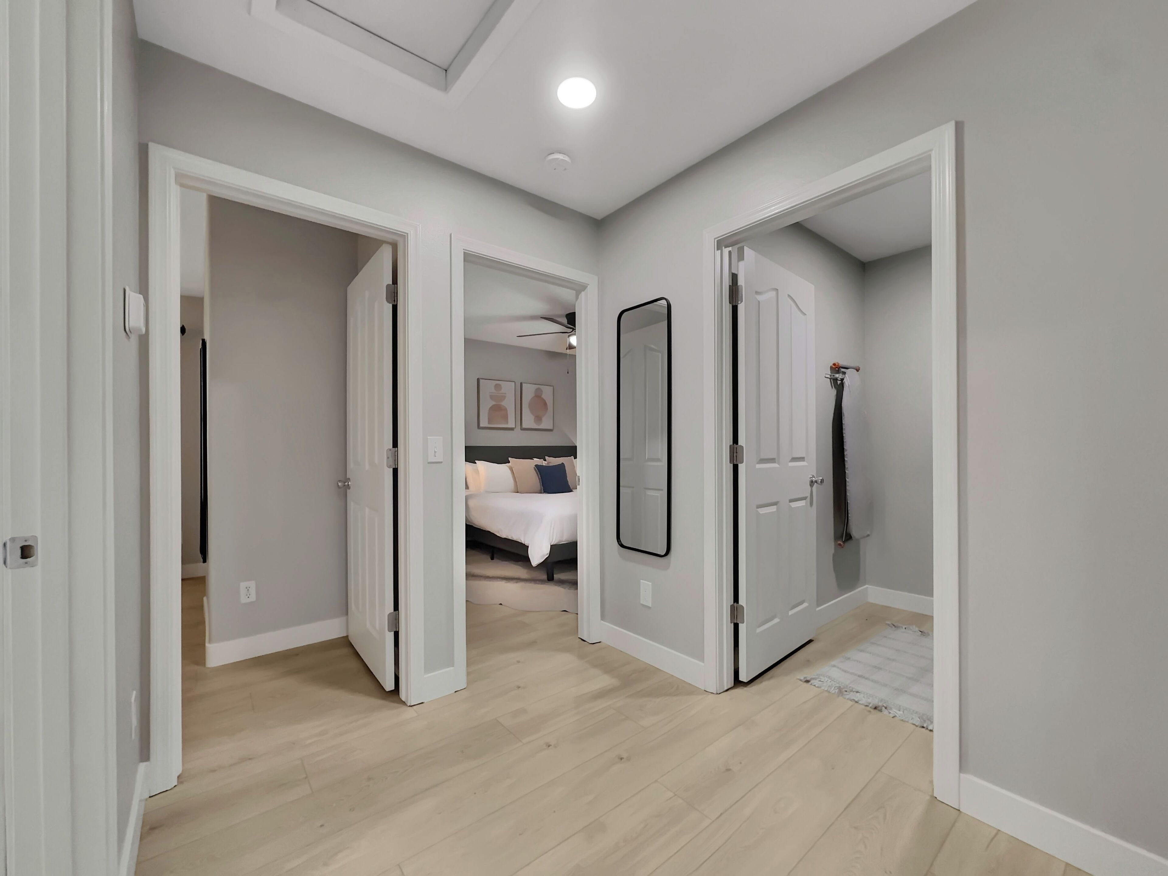 Un dormitorio moderno con cama, un espejo grande y un vestidor.