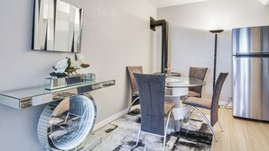 A modern kitchen with a built-in refrigerator, a glass dining table, and contemporary chairs. - 4 Mi to Broadmoor! Apt w/ Movie Theater & Mtn View (Colorado Springs)