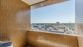 A tiled balcony with a view of a cityscape.