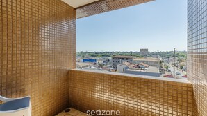 Een betegeld balkon met uitzicht op een stadsgezicht.