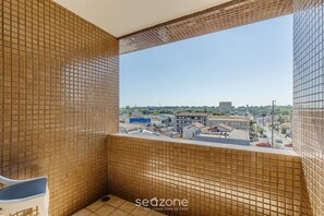 A tiled balcony with a view of a cityscape.