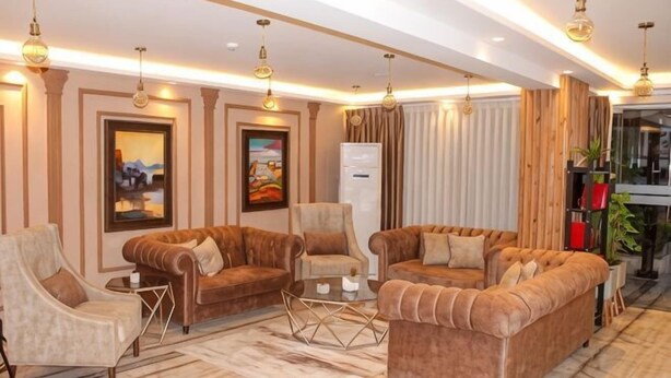 Ein modernes Wohnzimmer mit Sofas, Sesseln und einem Couchtisch.
