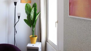 A room with a wooden table, a purple chair, a potted plant, a standing heater, and a poster on the wall. - Studio number 15 in Pantin (Pantin)