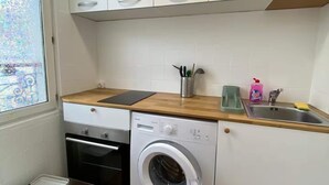 A compact kitchen with a washing machine, a sink, and a window. - Studio number 6 in Pantin (Pantin)