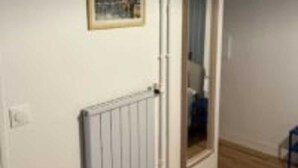 A room with a radiator, a framed picture on the wall, and a doorway leading to another room. - Studio number 7 in Pantin (Pantin)
