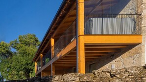 Un bâtiment moderne avec une base en pierre, une structure supérieure en bois et de grandes fenêtres.