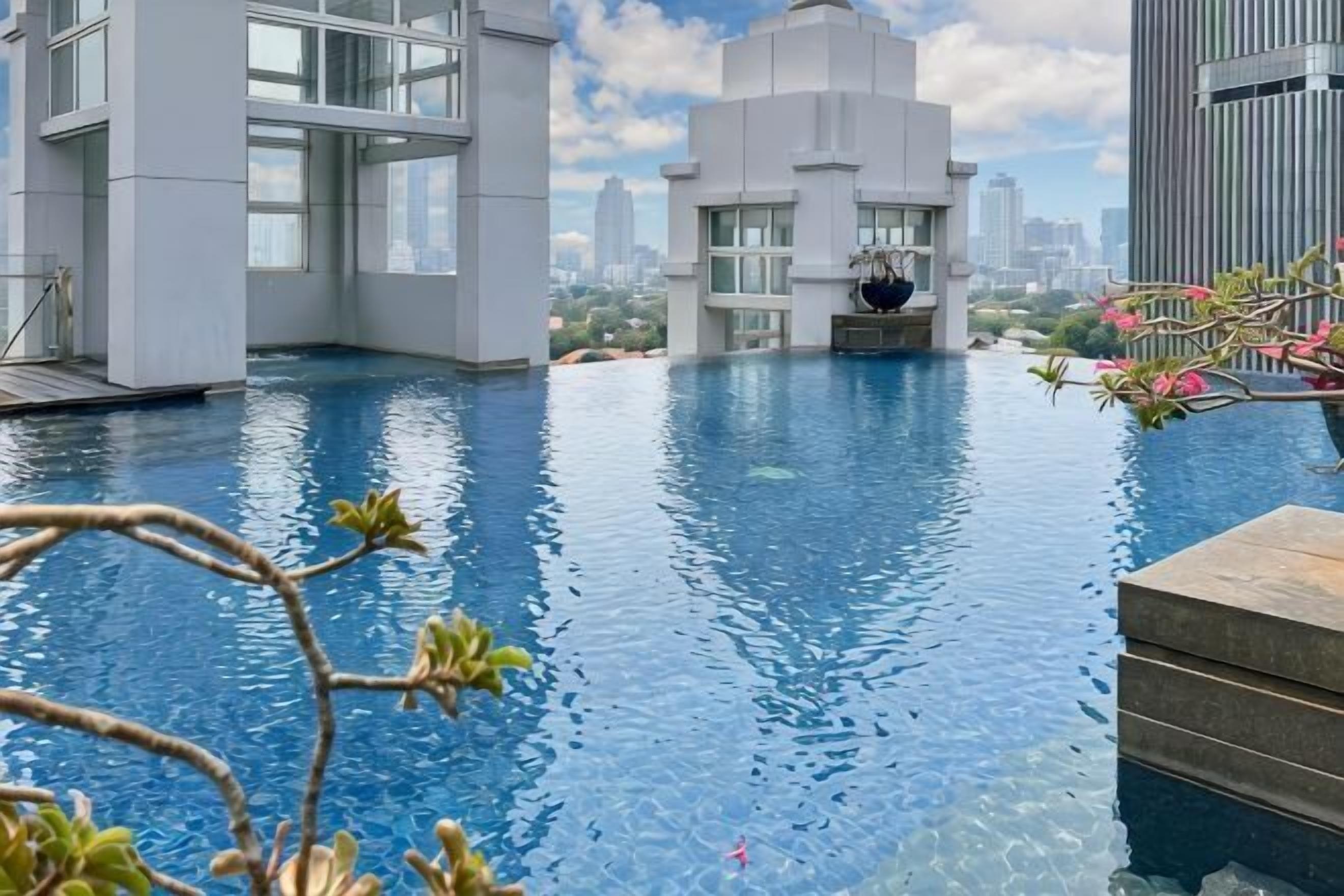 An infinity pool with modern architecture and a cityscape view.