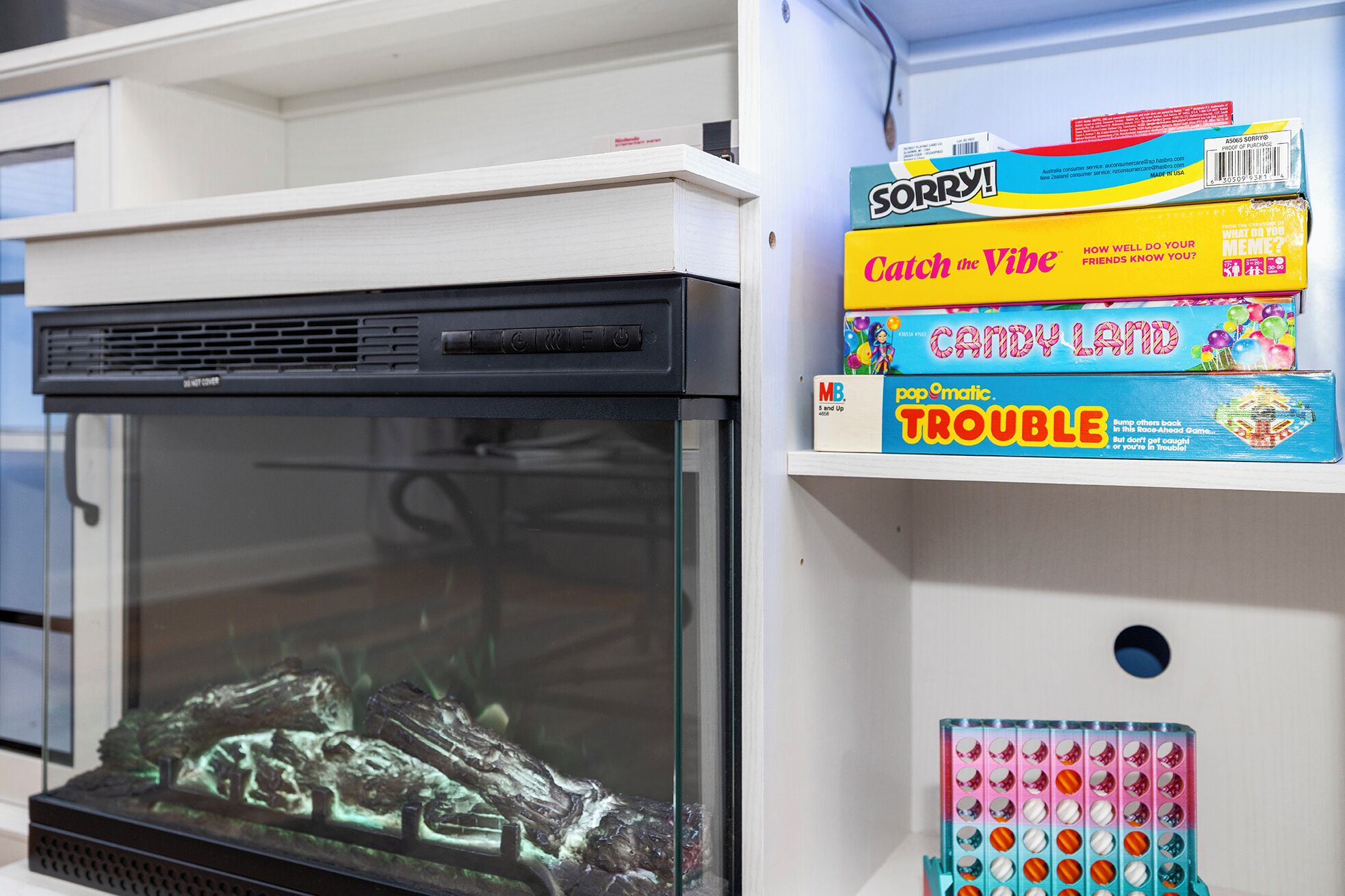 A fish tank with a rocky landscape and a shelf with colorful boxes.