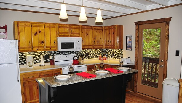 A kitchen with wooden cabinets, a microwave, a coffee maker, and a red kettle. - A CABIN ON PARADISE Tranquil cabin in Murphy - just 1 mile from JCC Folkschool (Murphy)