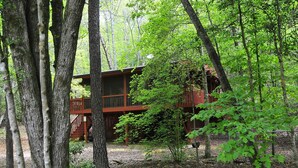 A cabin surrounded by trees with a wooden deck and a fenced area. - A CABIN ON PARADISE Tranquil cabin in Murphy - just 1 mile from JCC Folkschool (Murphy)