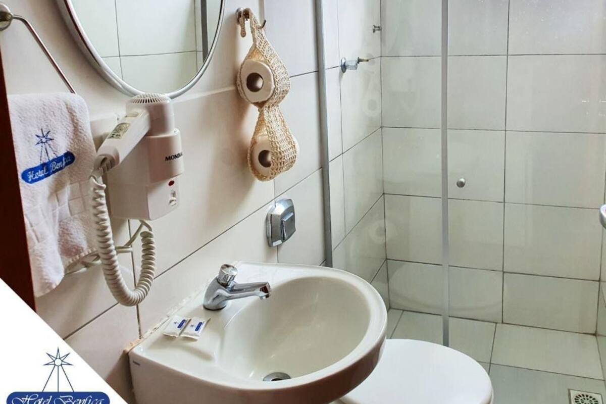 Un baño con lavamanos, inodoro y zona de ducha.