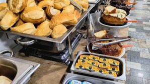 A buffet with various food items including pastries, sandwiches, and condiments. - Hotel Benfica (Aparecida)