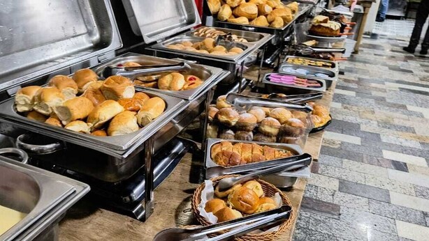 A buffet with various food items including rolls and pastries. - Hotel Benfica (Aparecida)